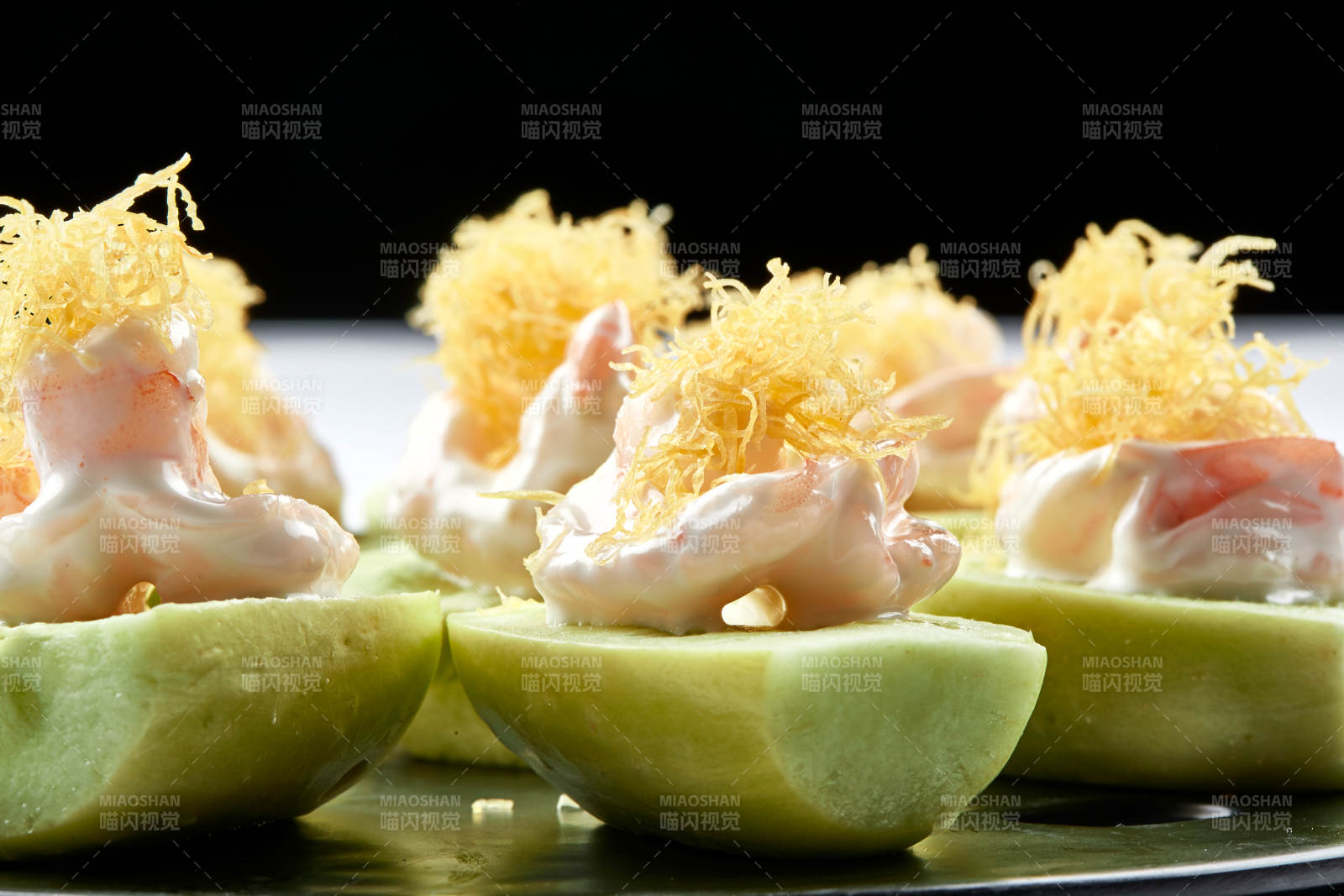 黑色瓷盤裝的沙拉大蝦仁