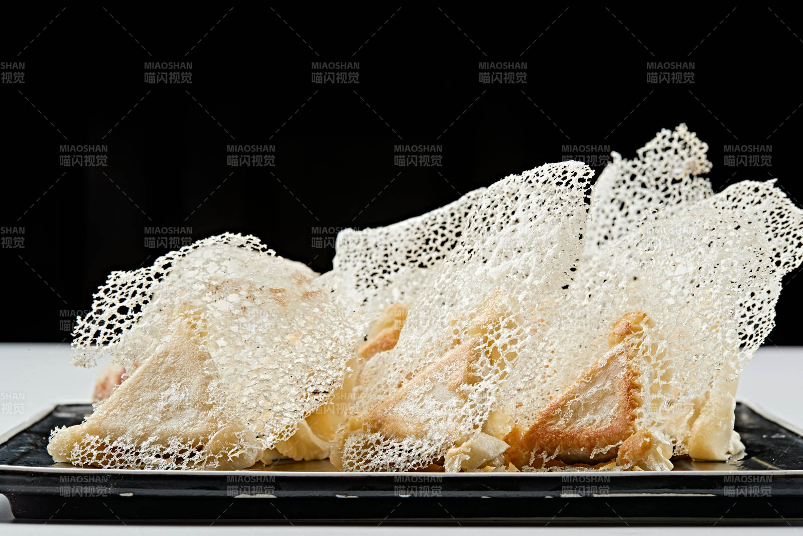 黑色瓷盤裝的漁網(wǎng)水煎包