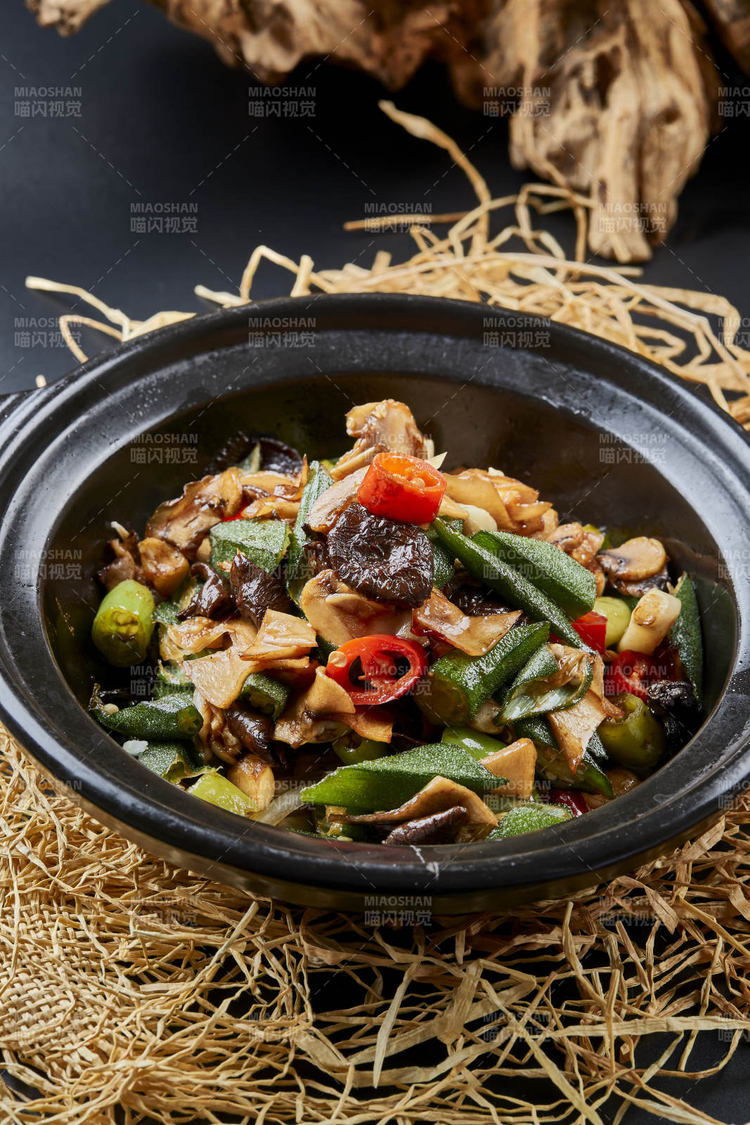 褐色砂锅装的酱包秋葵山珍菌
