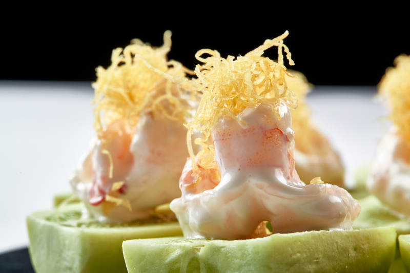 黑色瓷盘装的沙拉大虾仁