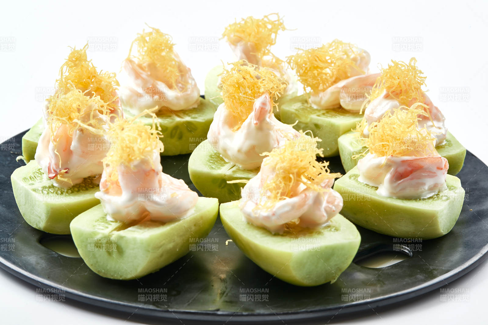 黑色瓷盤裝的沙拉大蝦仁