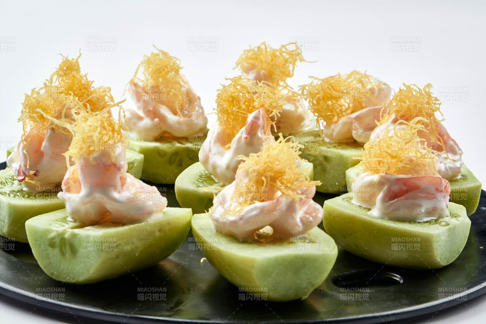 黑色瓷盤裝的沙拉大蝦仁