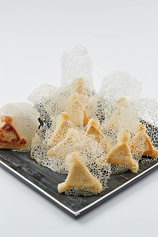 黑色瓷盘装的渔网水煎包