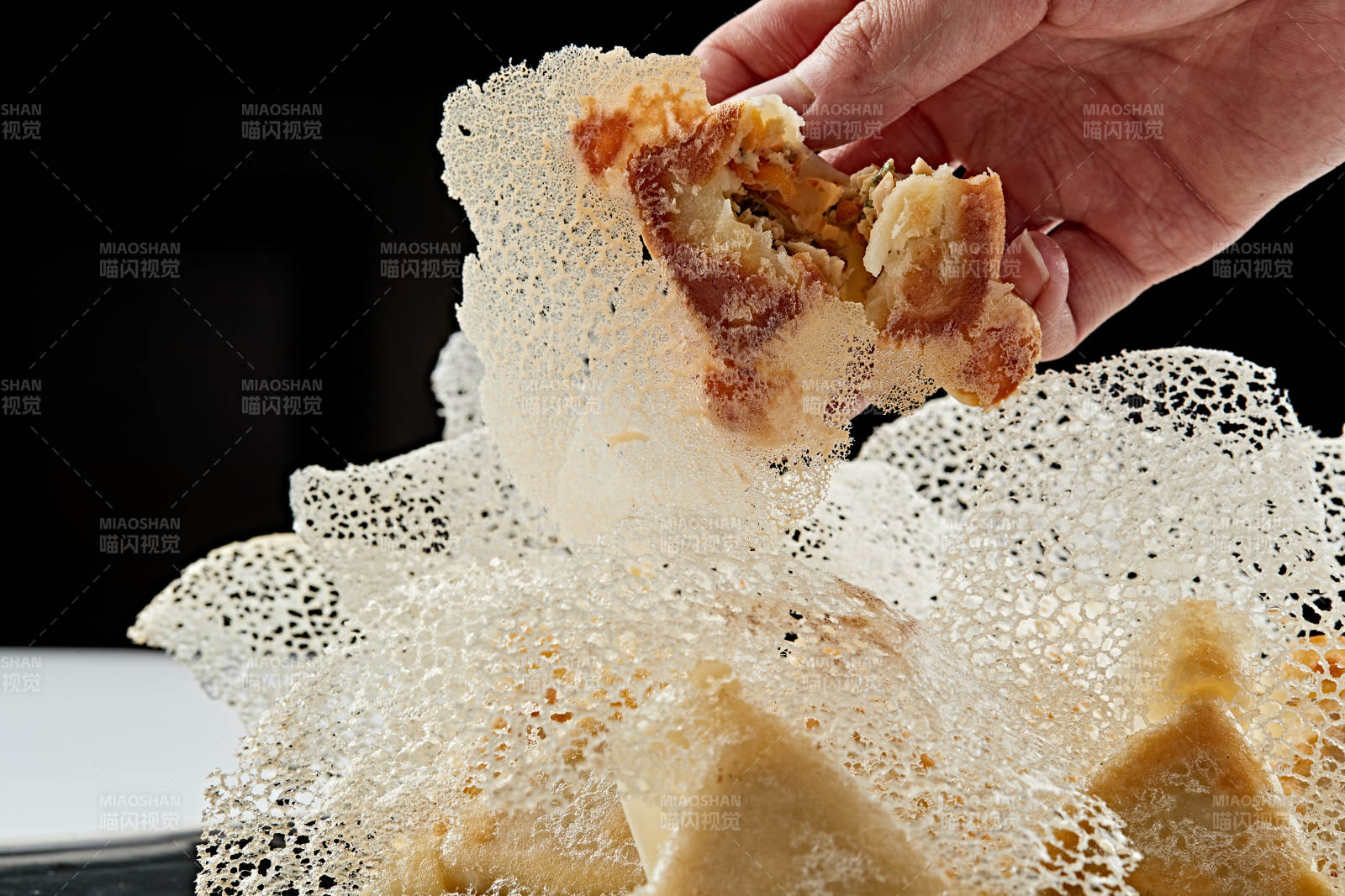 黑色瓷盘装的渔网水煎包