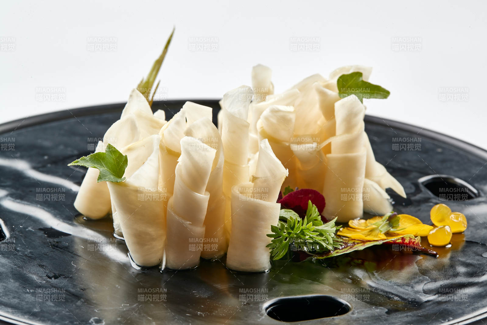 黑色瓷餐具装的鲜杏鲍菇刺身卷