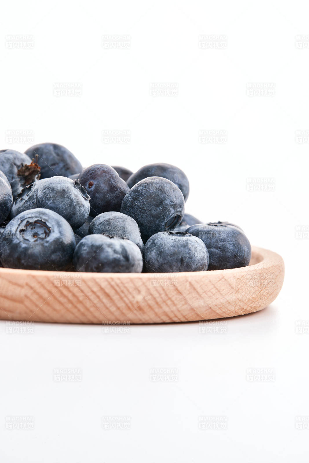 白色背景上摆放的水润新鲜蓝莓果