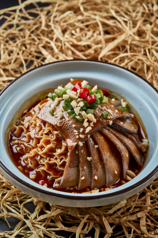 黑色背景上的瓷餐具装的川味夫妻肺片