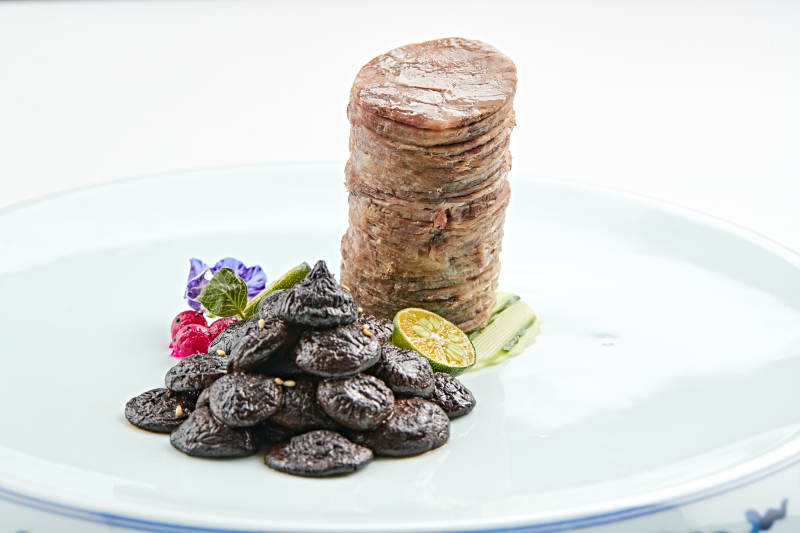 青花瓷盘装的酱腌口蘑配压肘花