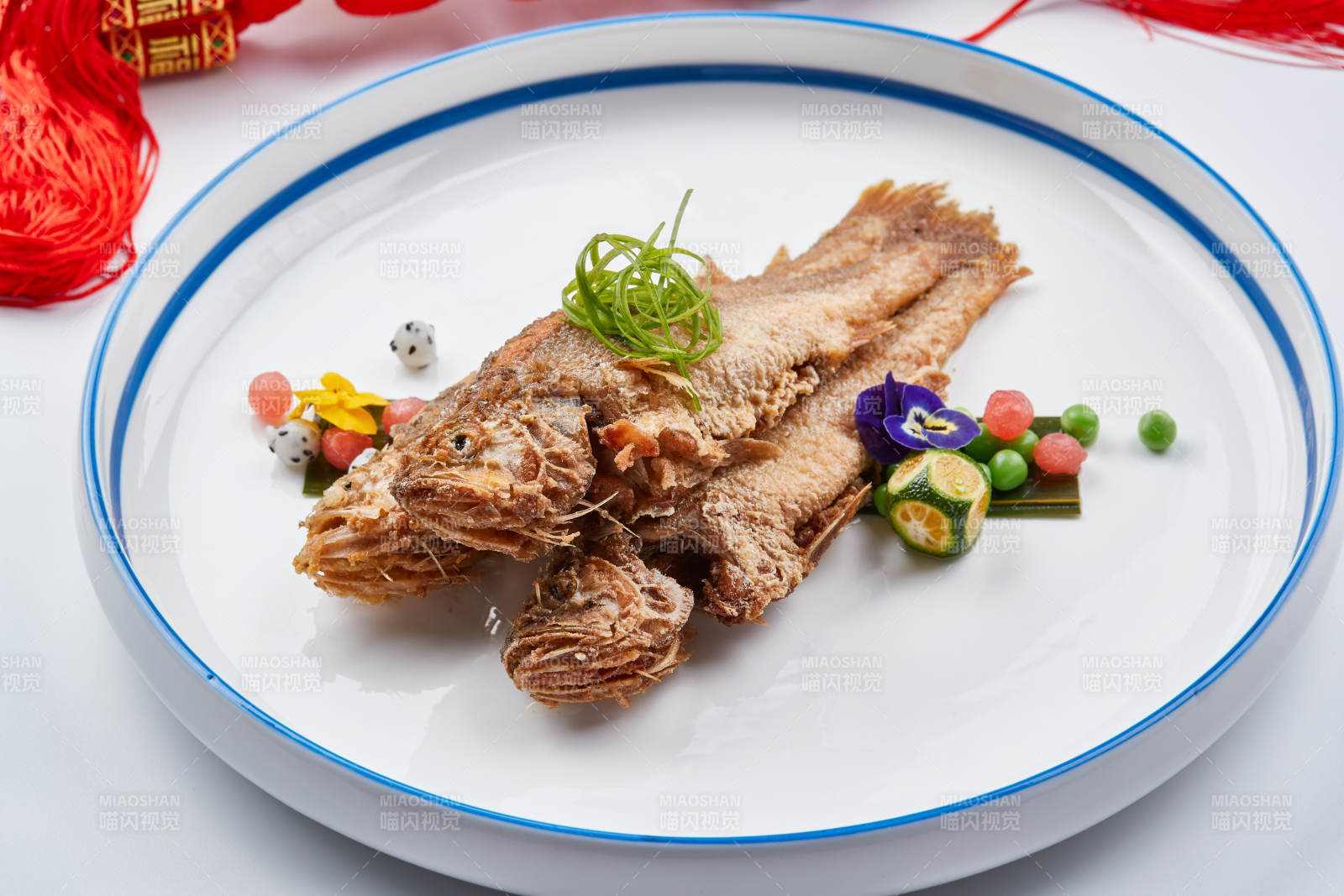 白色瓷盘装的油炸新鲜小黄鱼