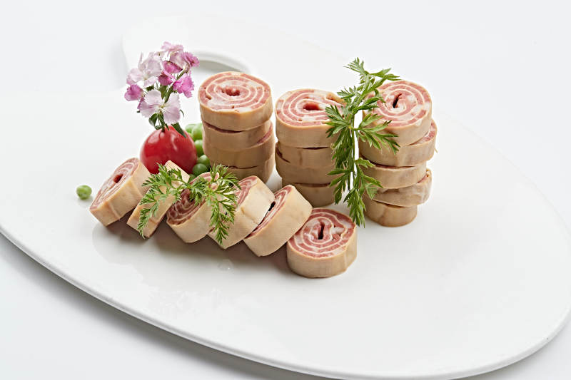 白色瓷盘组昂的豆腐皮熏肉卷切片