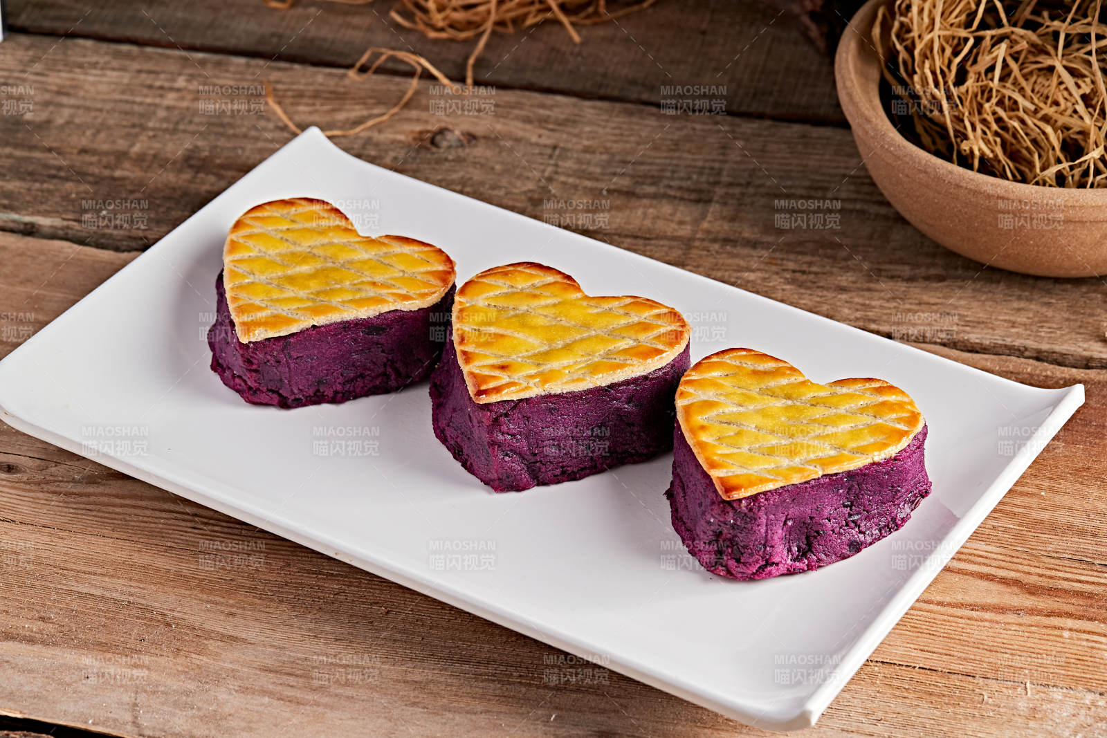 白色瓷盘装的茶餐烘焙酥皮心形紫薯泥
