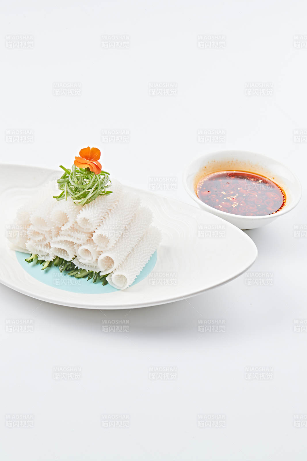 白色瓷盤裝的紅油墨魚卷