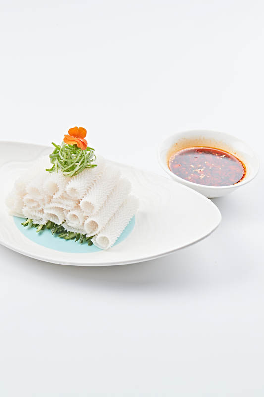 白色瓷盤裝的紅油墨魚卷