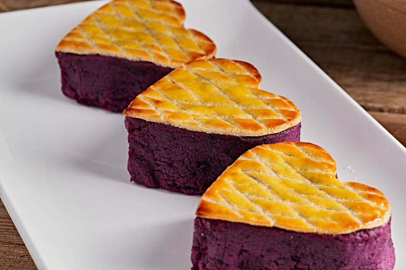 白色瓷盘装的茶餐烘焙酥皮心形紫薯泥