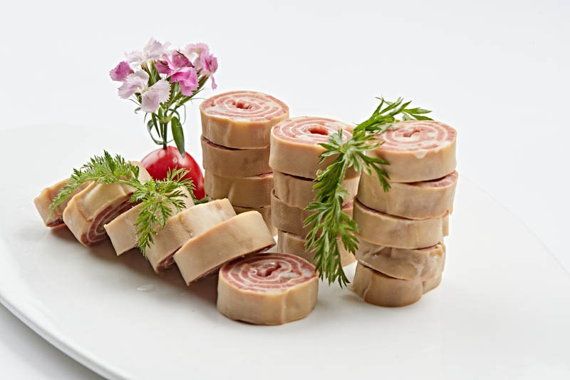 白色瓷盘组昂的豆腐皮熏肉卷切片