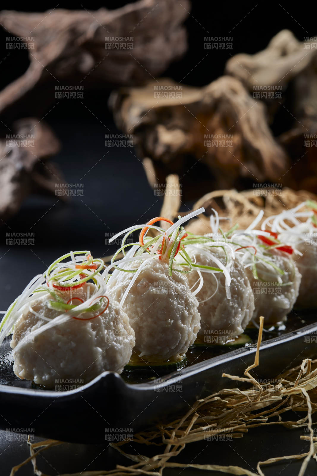 黑长瓷盘装的浇汁清汤萝卜丸子