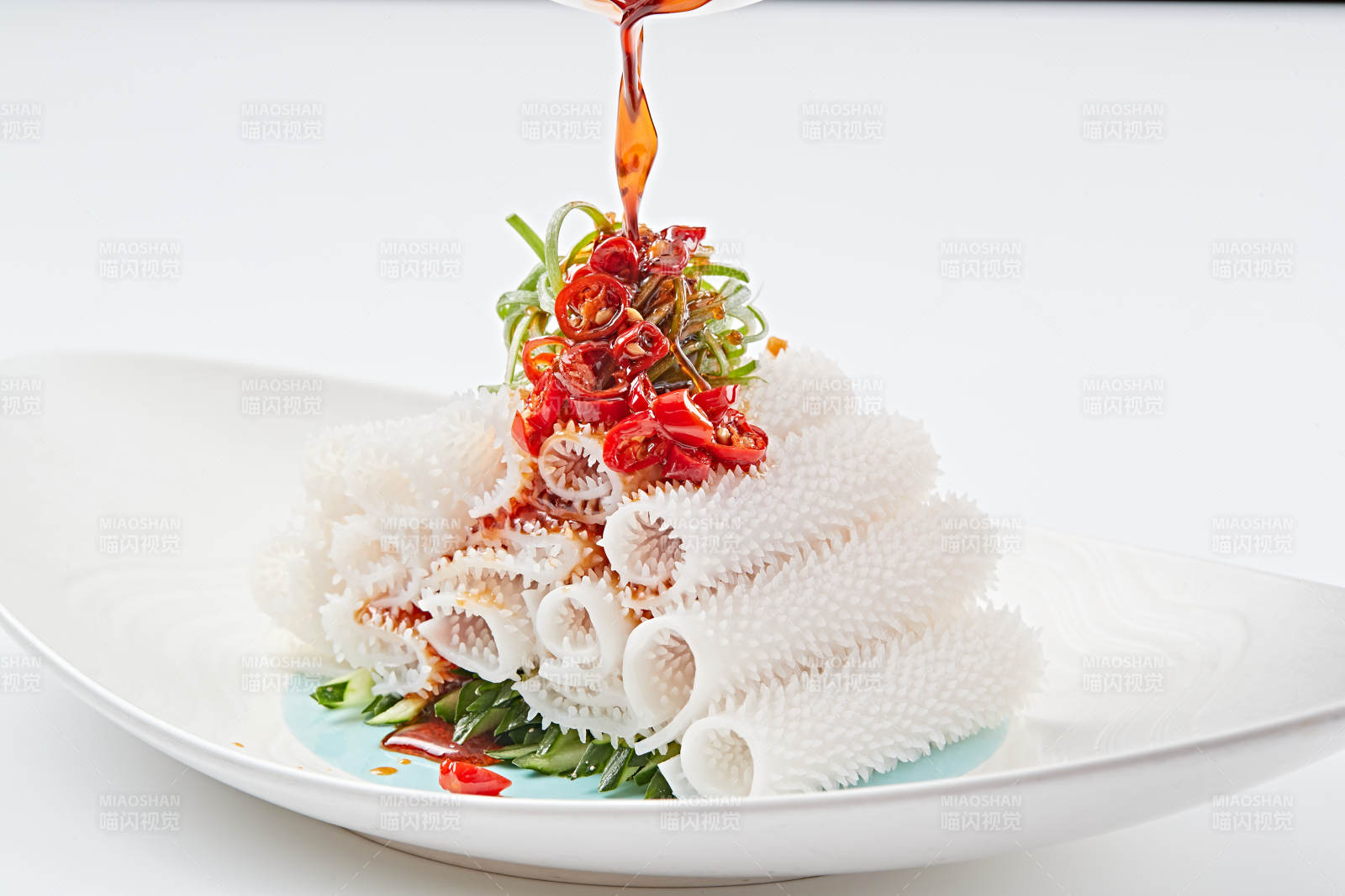 白色瓷盤裝的紅油墨魚卷