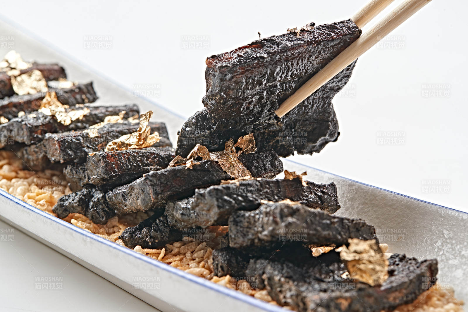 白色瓷盤裝的墨魚汁香煎豬五花肉