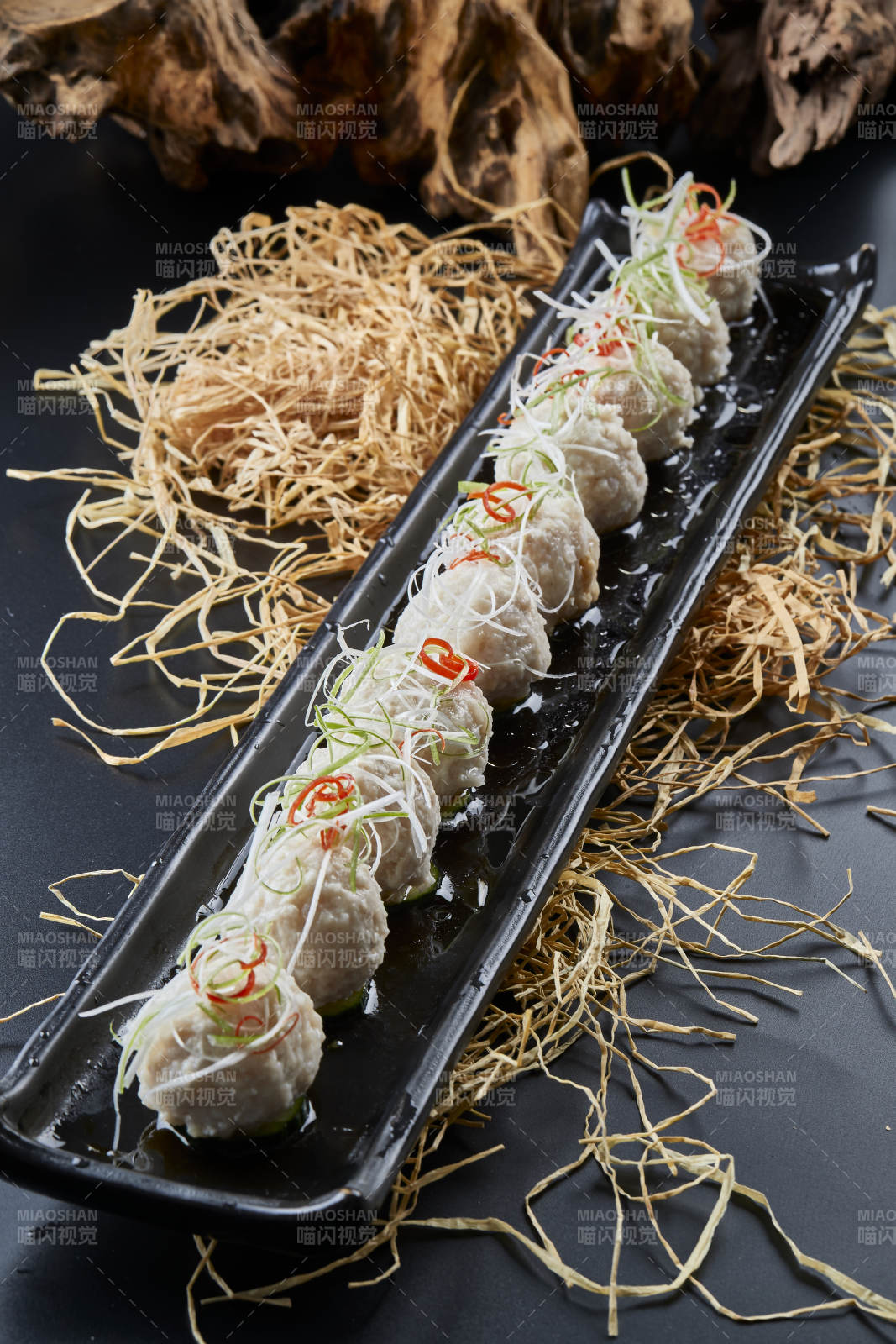 黑长瓷盘装的浇汁清汤萝卜丸子