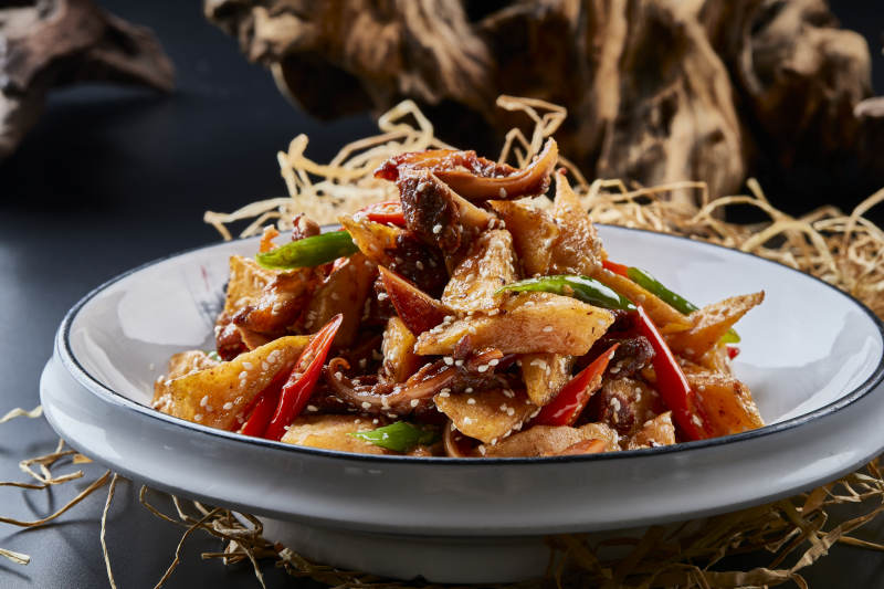 青瓷盘装的酱香红薯脆猪耳