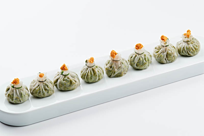 白色瓷餐具装的蟹籽糯米冰皮烧麦