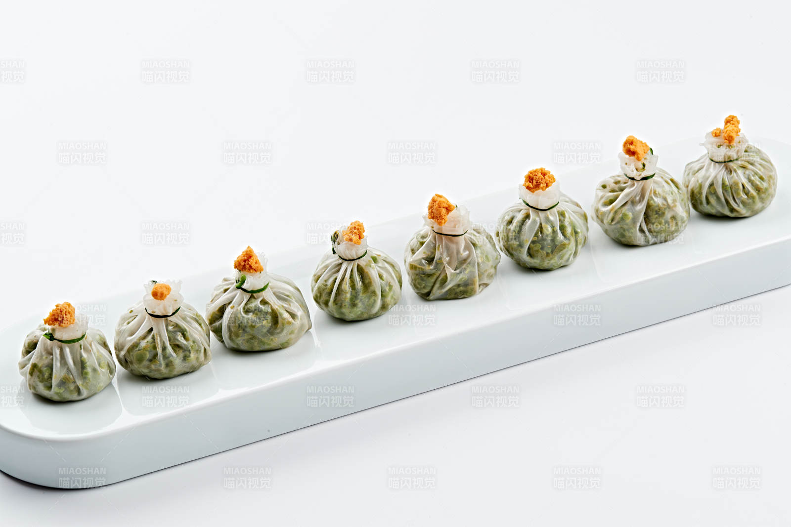 白色瓷餐具装的蟹籽糯米冰皮烧麦