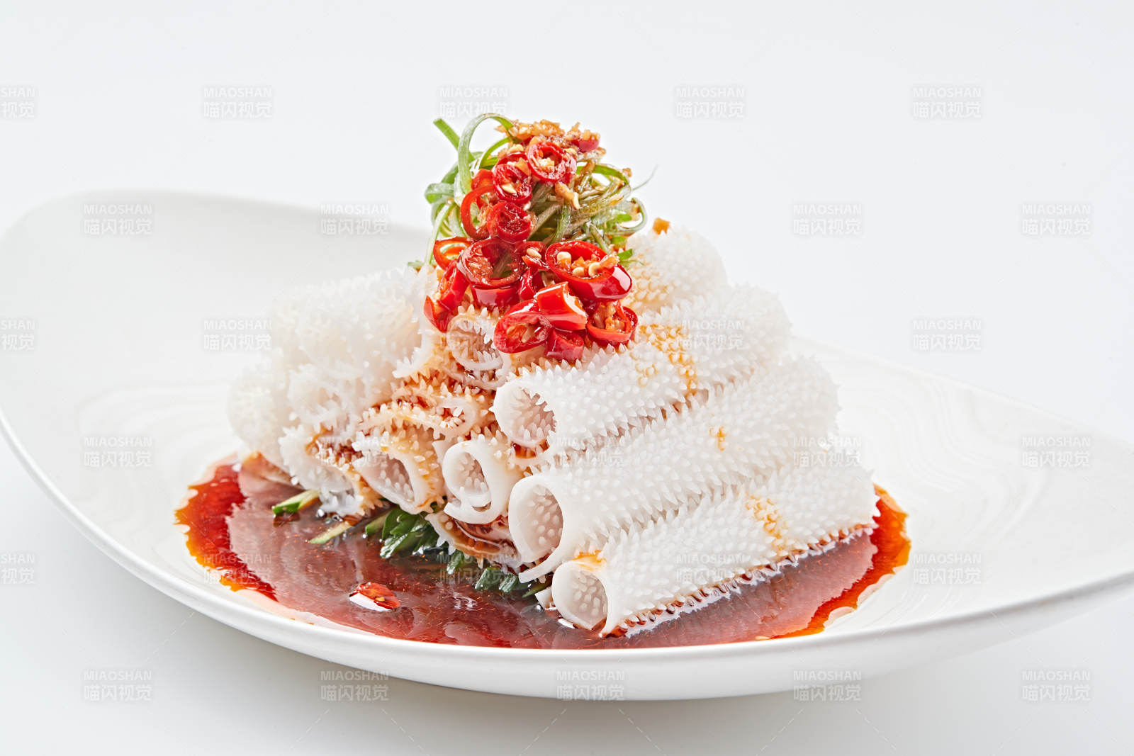 白色瓷盤裝的紅油墨魚卷