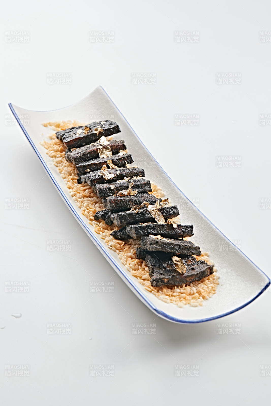 白色瓷盤裝的墨魚汁香煎豬五花肉