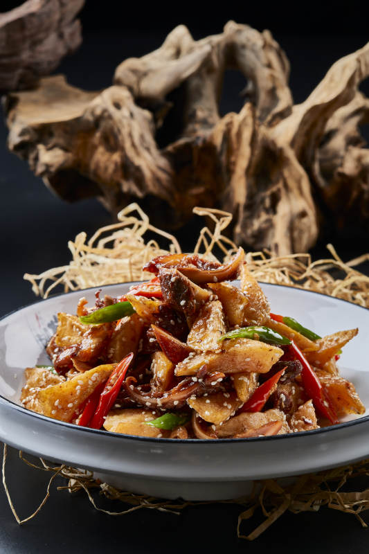 青瓷盘装的酱香红薯脆猪耳