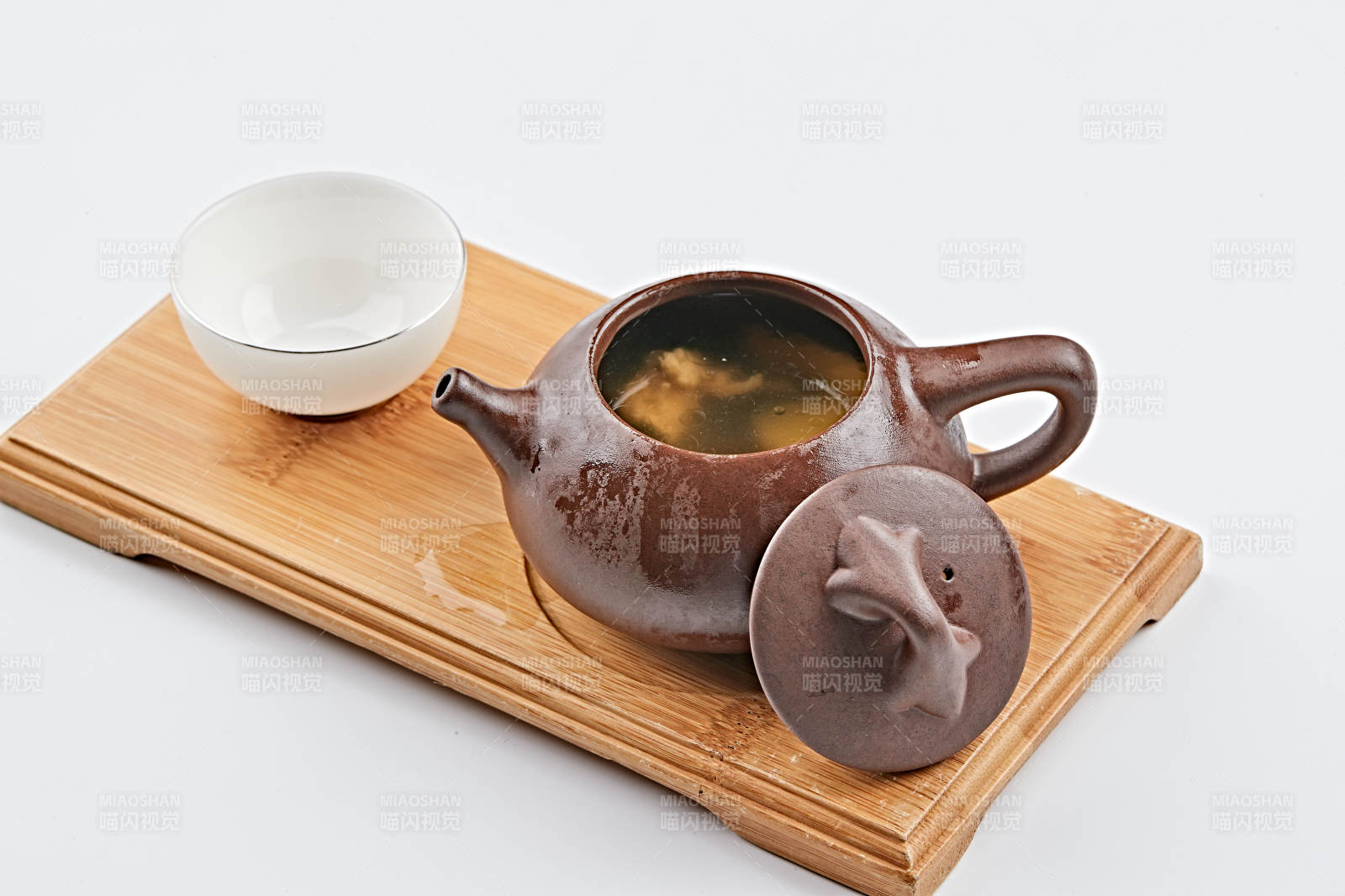白色背景上摆放的紫砂当归土鸡汤