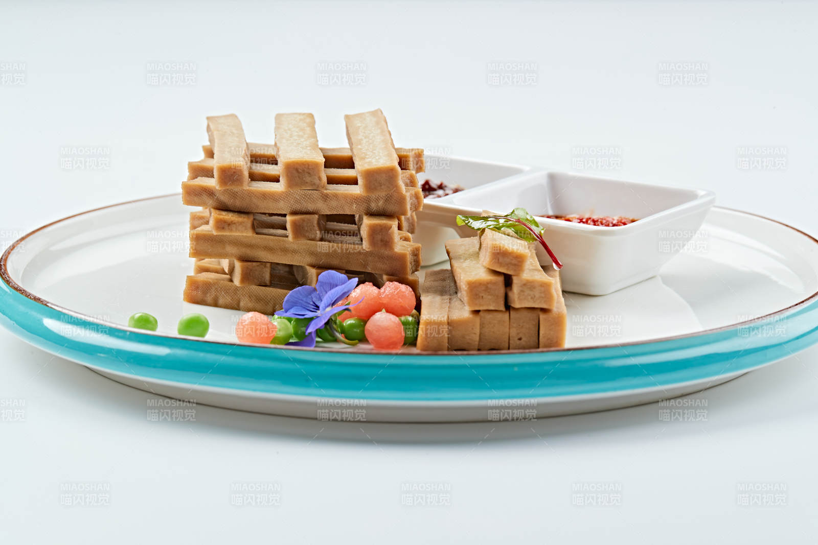 白色瓷盘装的蘸酱烟熏豆干