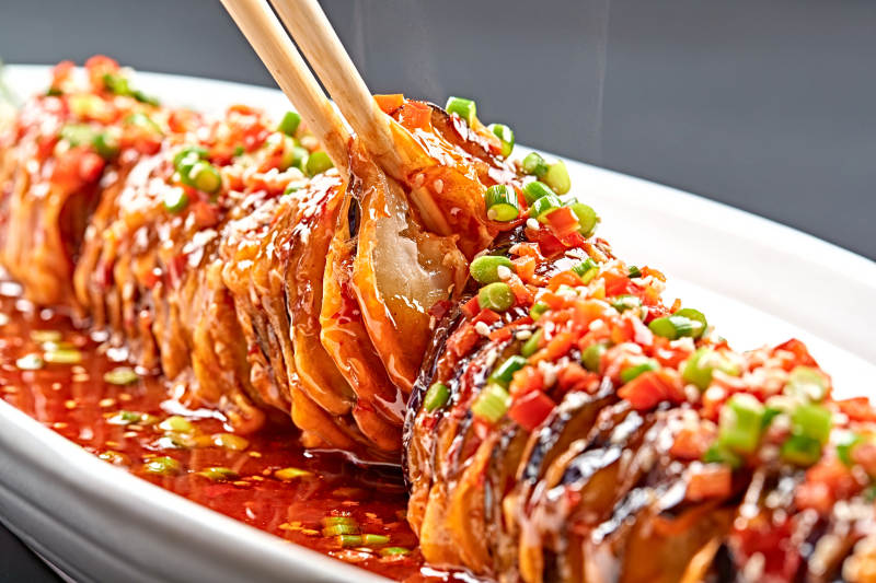 白色瓷盤(pán)裝的川味魚(yú)香紅油釀茄子