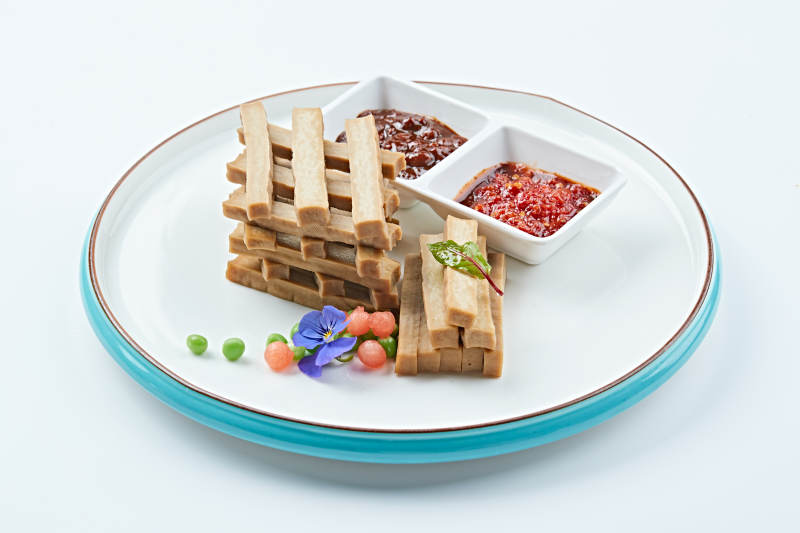 白色瓷盘装的蘸酱烟熏豆干