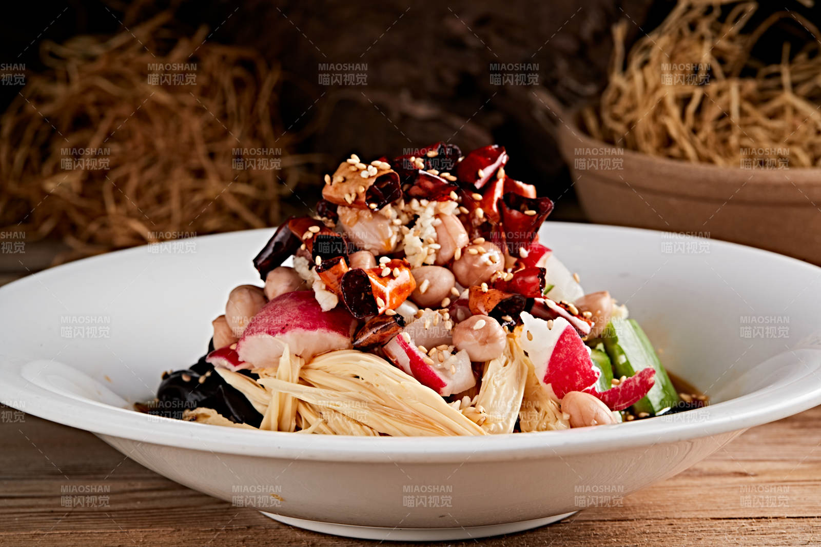 白色瓷盘装的捞汁果仁木耳黄瓜拌腐竹