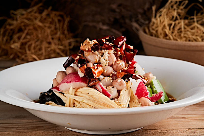 白色瓷盘装的捞汁果仁木耳黄瓜拌腐竹