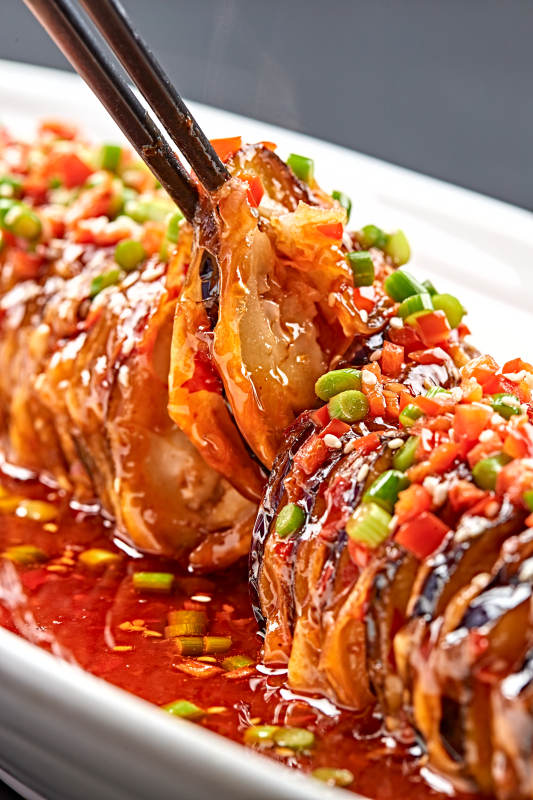 白色瓷盤(pán)裝的川味魚(yú)香紅油釀茄子