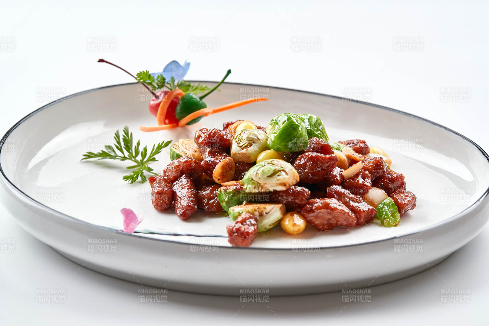 白色瓷盘装的酱爆银杏小甘蓝黑胡椒牛仔粒