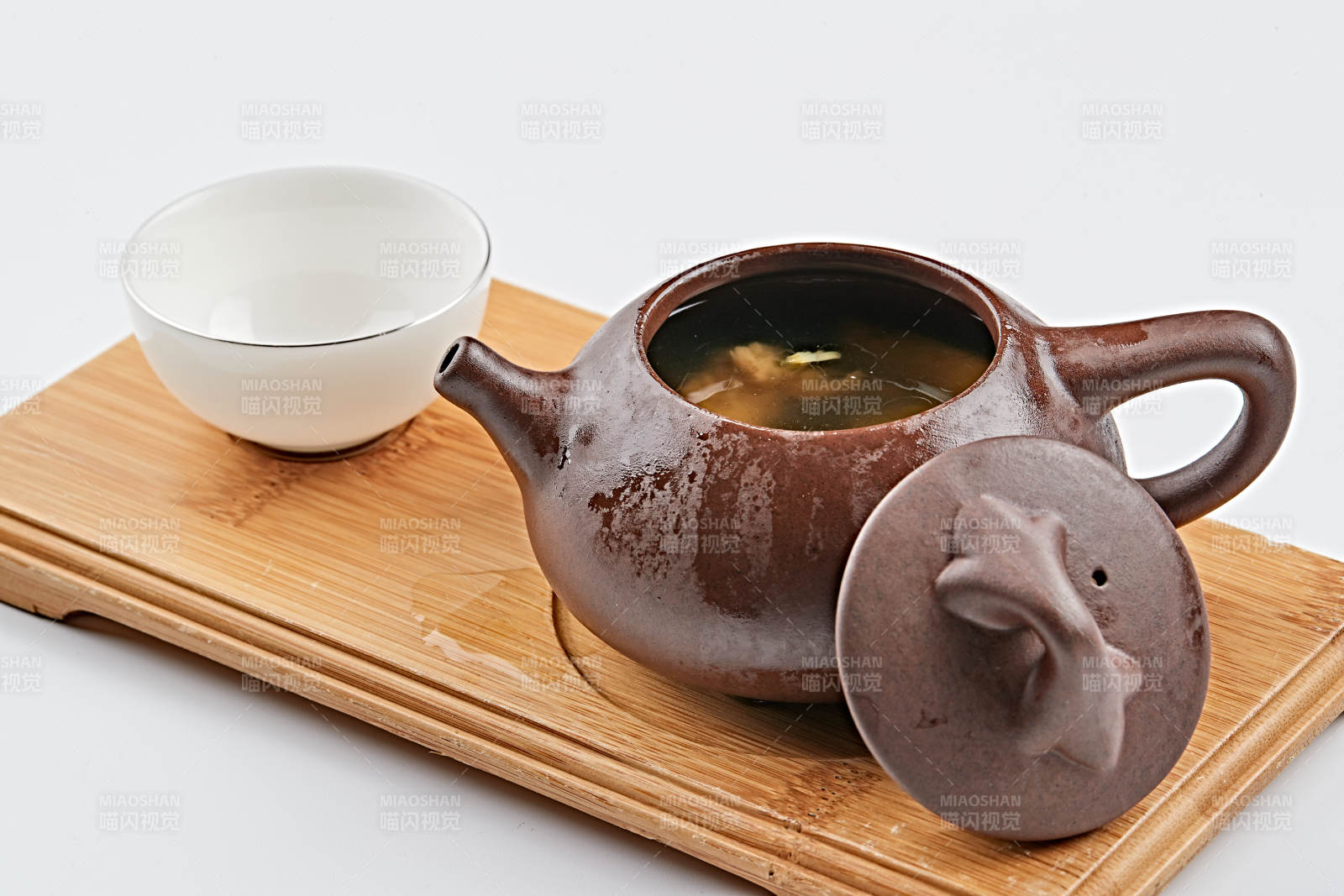 白色背景上摆放的紫砂当归土鸡汤