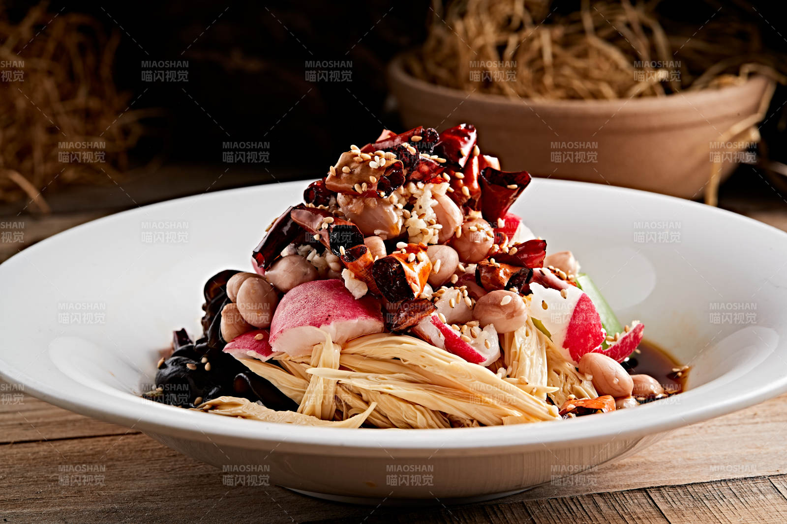 白色瓷盘装的捞汁果仁木耳黄瓜拌腐竹