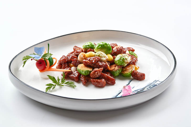 白色瓷盘装的酱爆银杏小甘蓝黑胡椒牛仔粒