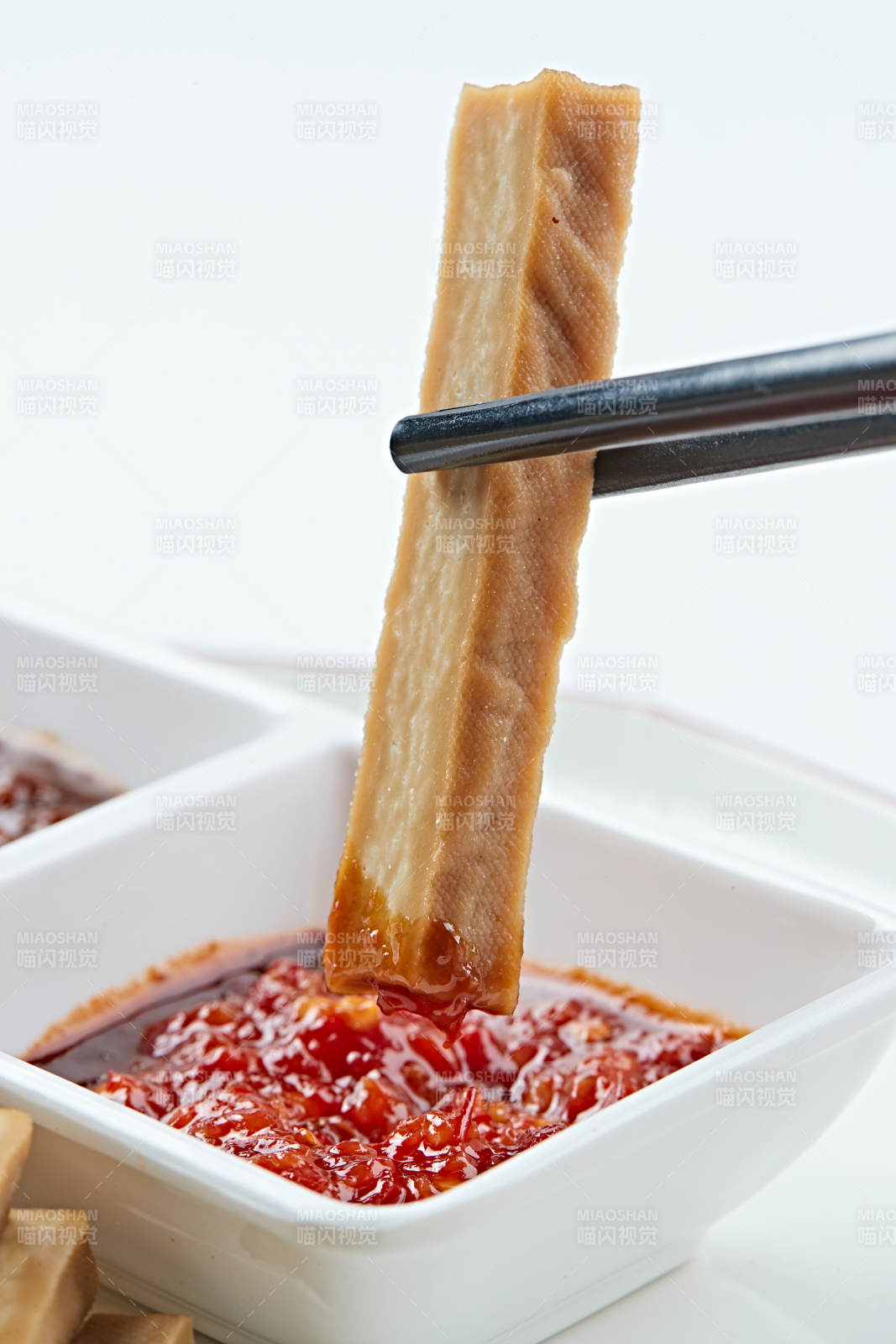 白色瓷盘装的蘸酱烟熏豆干