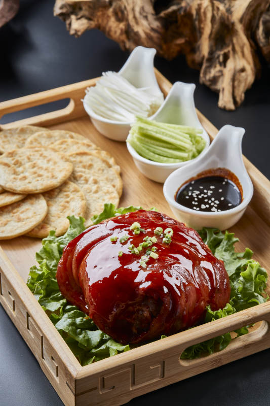 木质餐具装的杂粮饼时蔬配红烧肘子