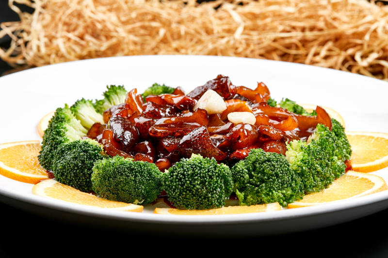 白色瓷盘装的酱爆海参