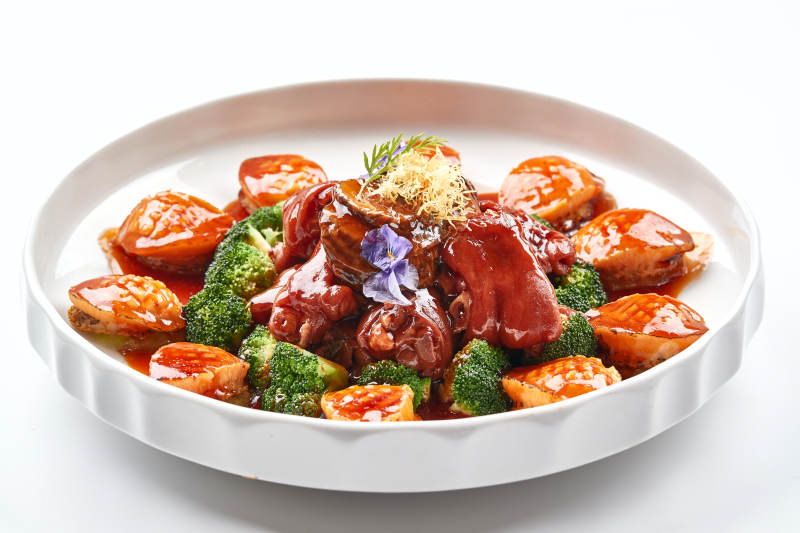 白色瓷盘装的酱烧猪肘鲜鲍鱼