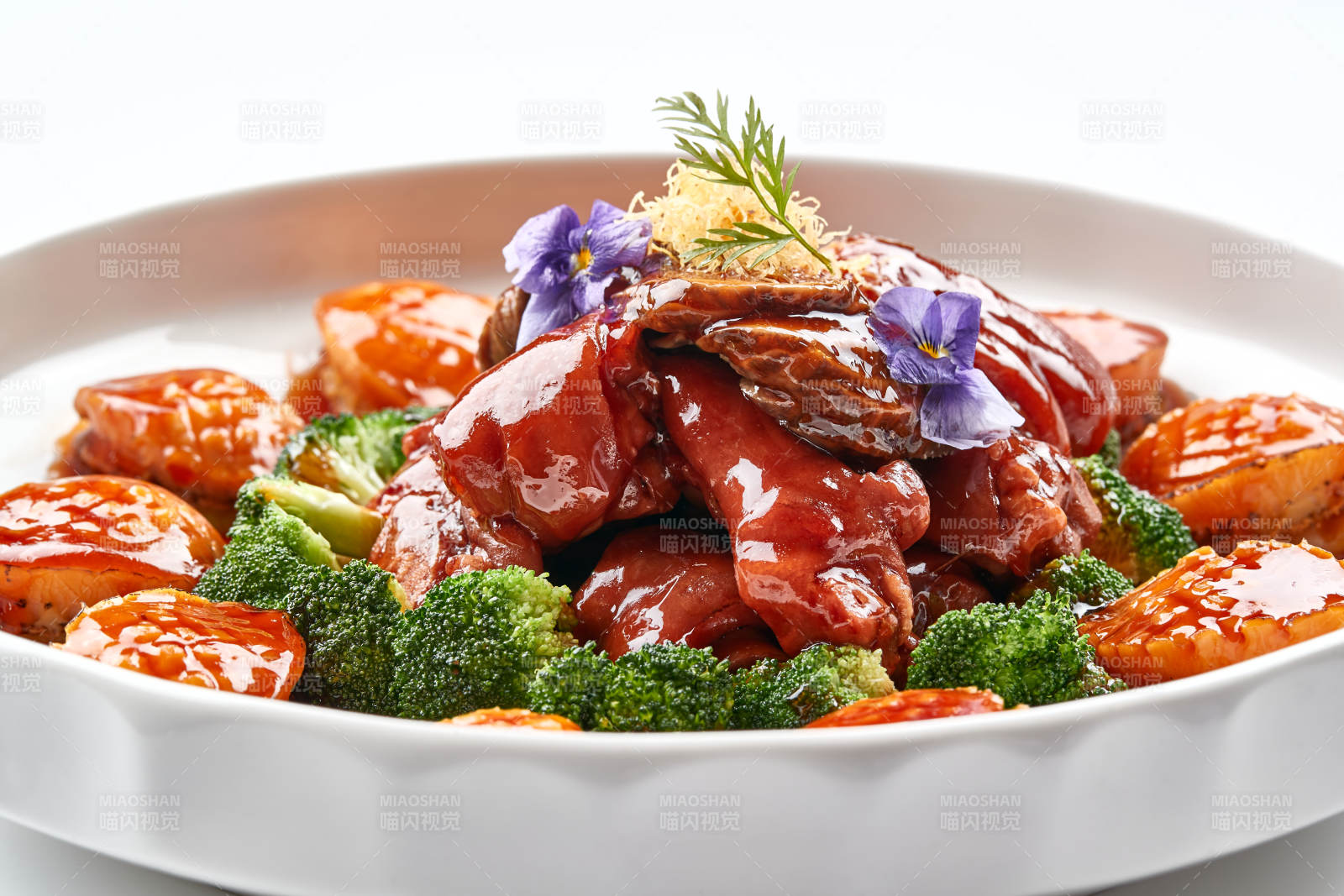 白色瓷盘装的酱烧猪肘鲜鲍鱼