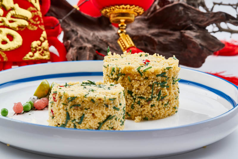 白色瓷盘装的的韭菜小米糕