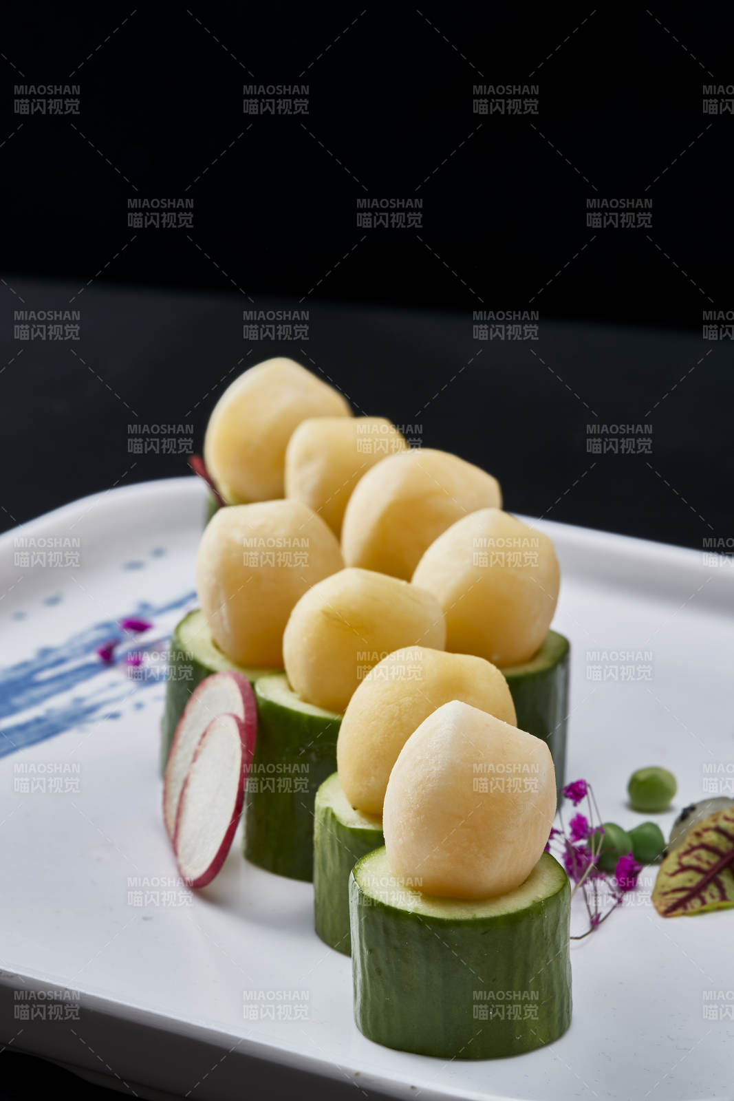 黑色背景上的創意美食手打馬鈴薯球配乳瓜段