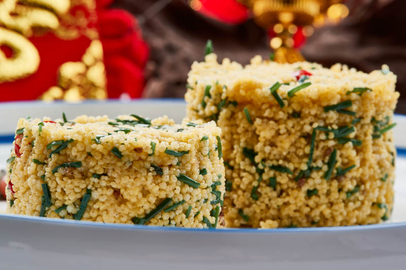 白色瓷盘装的的韭菜小米糕