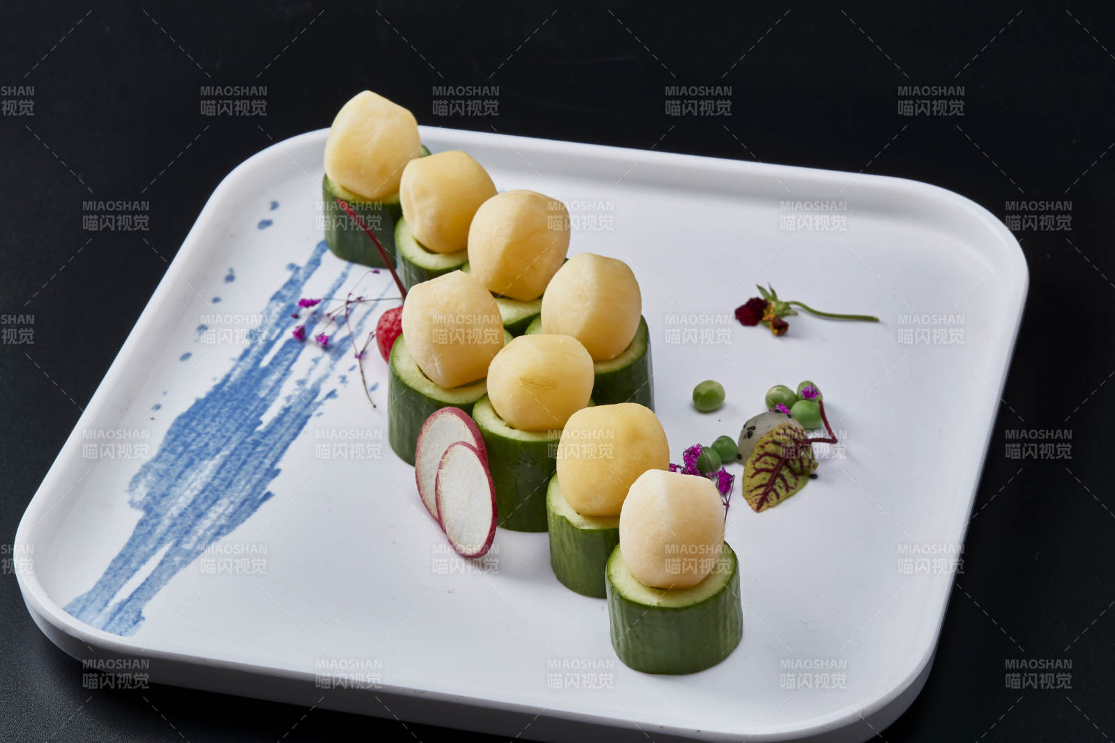 黑色背景上的創(chuàng)意美食手打馬鈴薯球配乳瓜段