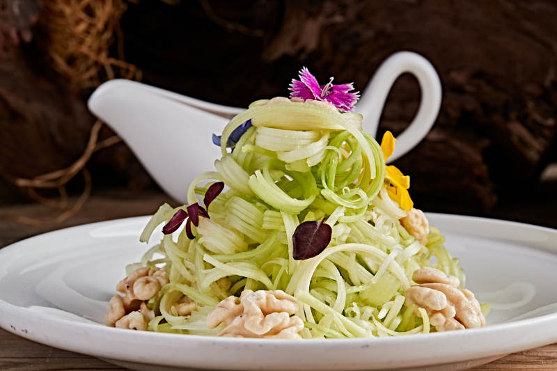 白色瓷盤裝的澆汁桃仁西芹絲